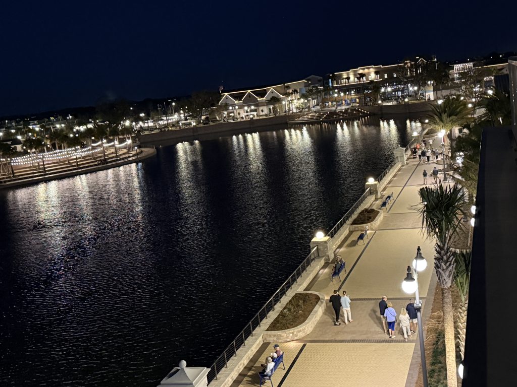 Eastport boardwalk and waterfront lit up at night in The Villages, Florida, viewed from Hotel Eastport